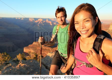 Caminhantes do casal no Grand Canyon. Imagem aspiracional de estilo de vida dos jovens feliz caminhadas a R Sul