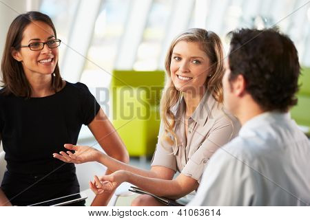 Businesspeople Having Meeting Around Table In Modern Office