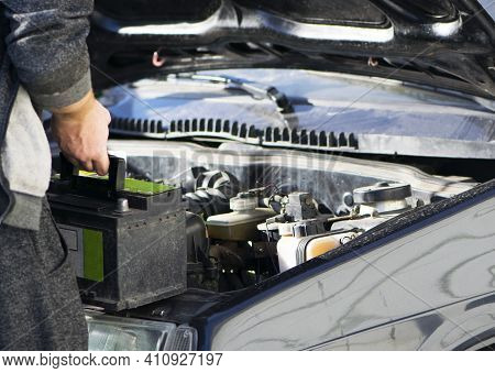 Put The Battery In The Car, Auto Repair. An Auto Mechanic Is About To Put In The Battery And Tighten