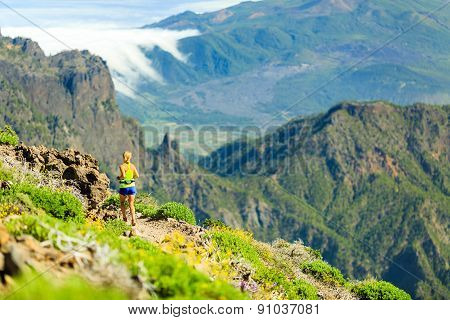 Woman Running In Mountains On Sunny Summer Day