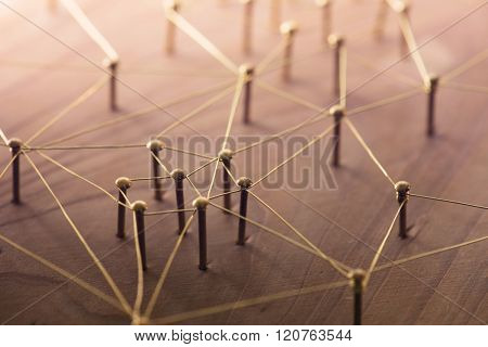 Linking entities. Network, networking, social media, connectivity, internet communication abstract. Web of thin gold wires on rustic wood.