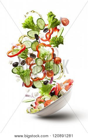 flying salad isolated on white background. Greek salad: red tomatoes, pepper, cheese, lettuce, cucumber, olives and olive oil