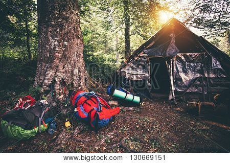 Backpacks and abandoned house camping outdoor Travel Lifestyle hiking equipment forest nature on background