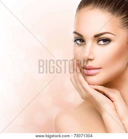 Beautiful Young Woman with Clean Fresh Skin close up isolated on white. Beauty Portrait. Spa Woman Smiling and touching her skin. Perfect Fresh Skin. Pure Beauty Model. Youth and Skin Care Concept 