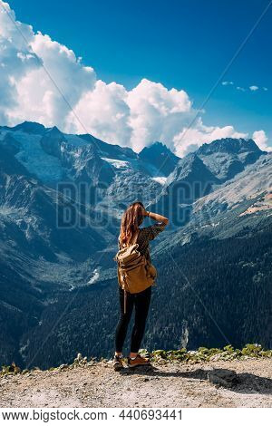 A Woman Is Traveling In Caucasus, Russia. Mountain Tourism In Russia. Walking Tour Of The Mountains 