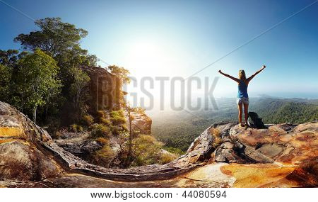 享受谷视图从顶部的一座山的背包徒步旅行者