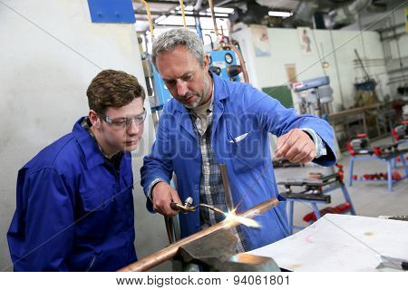 Teacher with student in metallurgy workshop