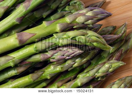 Fresh asparagus on wooden cutting board.  Macro with shallow dof