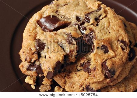 Chunky chocolate chip cookies still warm from the oven.  Macro showing texture and details of melting chocolate.