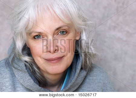 Casual retrato da mulher madura feliz com cabelo branco natural e maquiagem mínima.