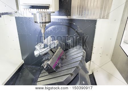 The 5-axis CNC machine while cutting the sample part of aircraft.The spindle of 5 axis CNC machining center while cutting turbine sample part of aircraft.