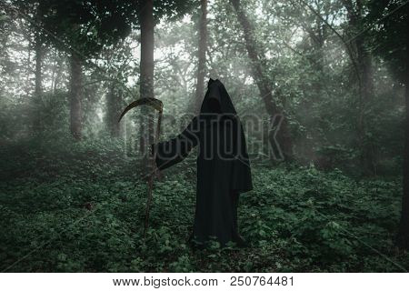 Death in a black hoodie with a scythe in forest