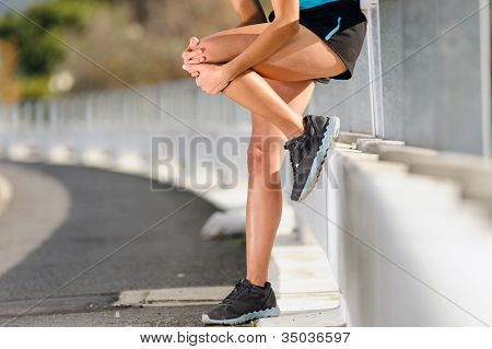 knee injury for athlete runner. woman in pain after hurting her leg while training for fitness marathon