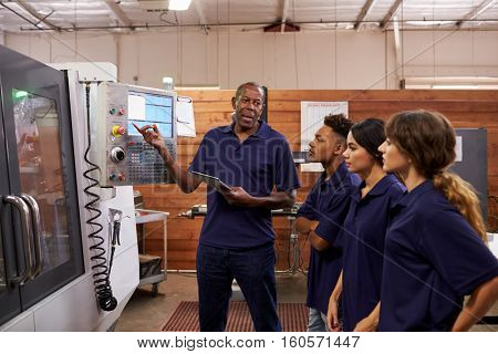 Engineer Training Apprentices On CNC Machine