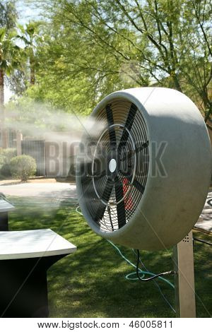 een water mister ventilator blaast koud water in de lucht om het gebied buiten afkoelen op een warme zomerdag