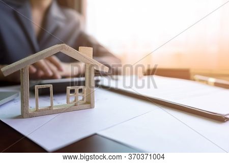 Real Estate Agent Or Realtor Calculating Price Of House In Purchase Agreement Behind The Home Archit