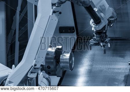 The Automatic  Robotic Arm Gripping The Metal Parts From Cnc Lathe Machine. The Hi-technology  Mater