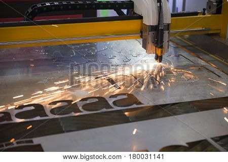 The CNC laser cut machine while cutting the sheet metal with the sparking light.The hi-precision sheet cutting process by laser cut