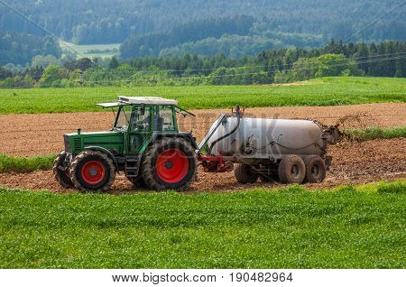 Tractor With Trailer Fertilizing Field With Natural Manure