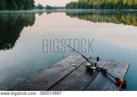 Fishing Rod, Spoon, Hooks On A Brown Wooden Background. Fishing Bait. Close Up. Throw-line. Fishing 