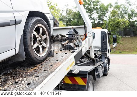 Cable Attached To Broken Down Car Being Pulled Onto Tow Truck