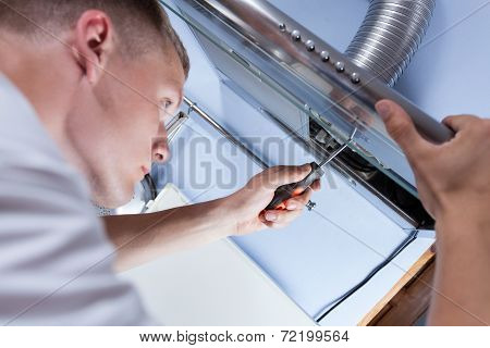 Repairman Mending A Kitchen Extractor