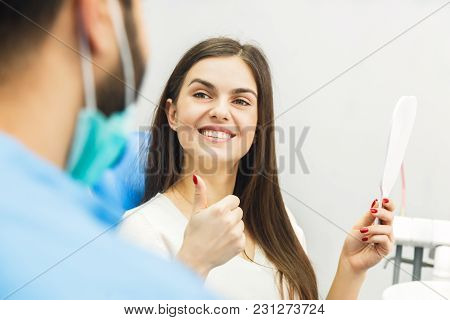 Dentist Finishing Successful Teeth Restoration, Black Haired Doctor, In Green Mask, Giving To Happy 