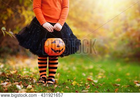 Little Girl In Witch Costume Playing In Autumn Park. Child Having Fun At Halloween Trick Or Treat. K