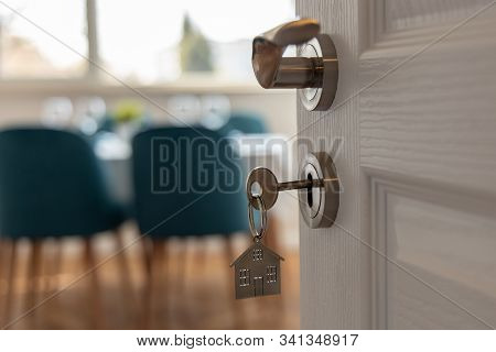 Open Door To A New Home. Door Handle With Key And Home Shaped Keychain. Mortgage, Investment, Real E