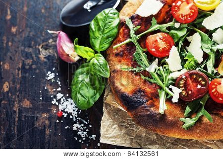 pizza and fresh italian ingredients on a dark background