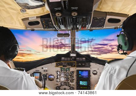 Pilots in the plane cockpit and sunset