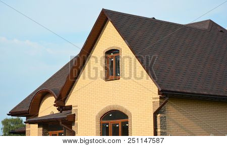 Roofing Construction House Building With Asphalt Shingles, Rain Gutter And Roof Ventilation. Close U