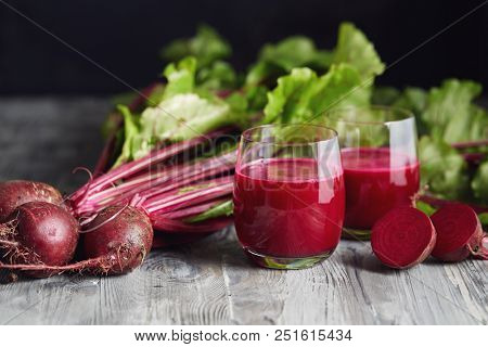 Detox juice with freshly picked bunch of beetroot. Fresh beets on a wooden table. 