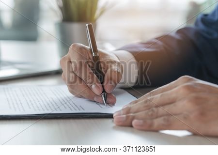 Contract Document Official. Close Up Person Signing His Signature To Agreement Document To Guarantee