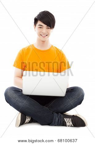 Happy Young Student Sitting On Floor And  Using Laptop