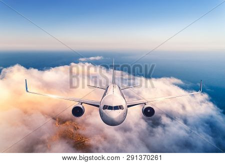 Airplane Is Flying Over Clouds At Sunset In Summer. Landscape With Passenger  Airplane, Low Clouds, 