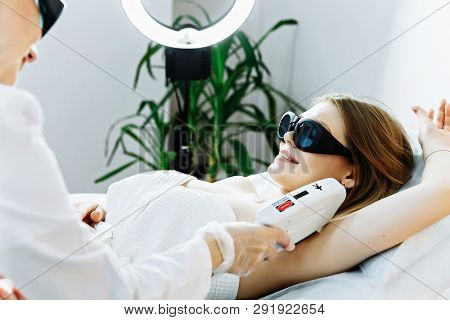 Body Care. Underarm Laser Hair Removal. Beautician Removing Hair Of Young Woman's Armpit. Laser Epil