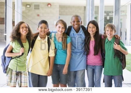 Six élèves debout extérieur école ensemble souriant