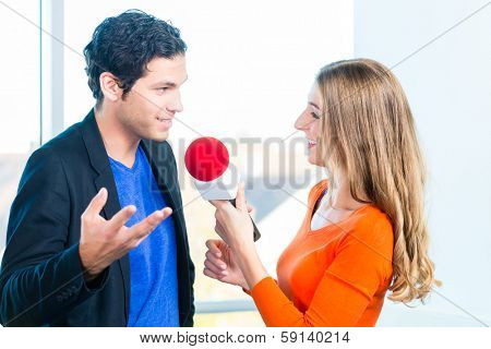 Female Radio host doing interview with Studio guest in radio station during a show for radio live in the Studio