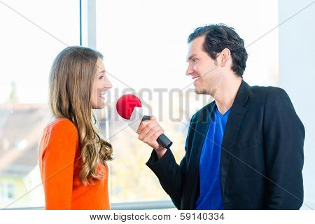 Female Radio host doing interview with Studio guest in radio station during a show for radio live in the Studio