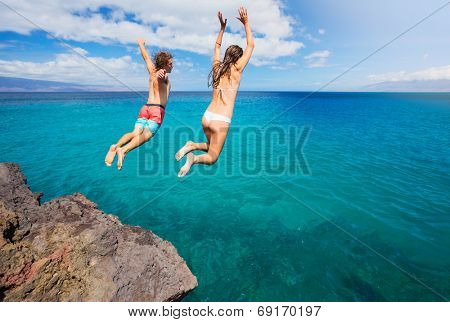 Friends cliff jumping into the ocean, summer fun lifestyle.