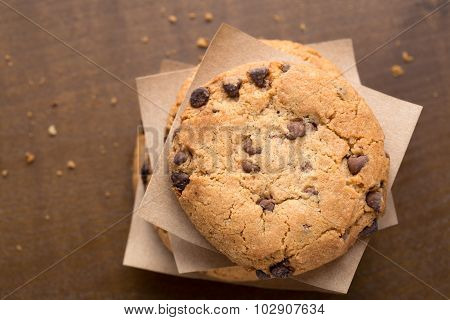 Stacked chocolate chip cookies on brown wooden table