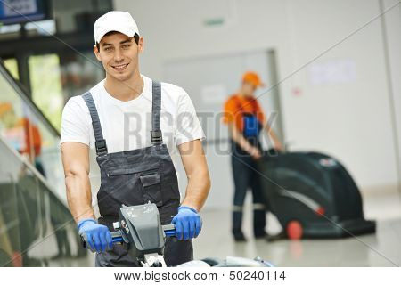 Cleaner male man workers with mop in uniform cleaning corridor pass or hall floor of business building