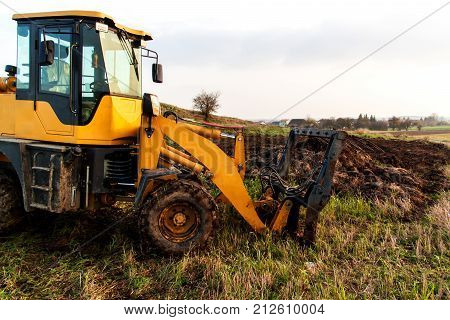 Dredger with natural manure loading trailer for field fertilization. Agricultural machine for fertilizing. Cow Dung