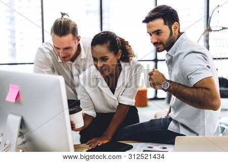 Group Of Casual Business Working Discussing Strategy And Documents With Desktop Computer.creative Bu