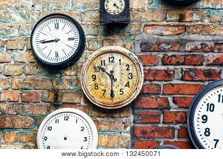 Grunge background with old watch. Time concept. Retro clocks on the wall. Old antique clock on aged red brick wall background. Vintage clocks.