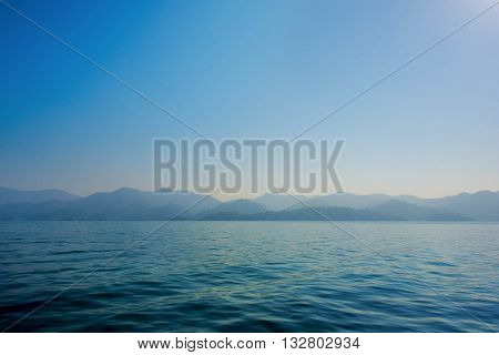 Simple sea and mountain Blue Sea and shade of mountain as defocused on sea. And nothing on sea. no people on sea.