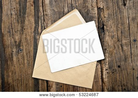 Blank card and envelope on old wooden background