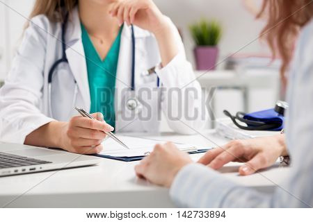 Doctor consulting patient hands closeup. Patient sitting at doctor office. Diagnostic prevention of women diseases healthcare medical service consultation or education healthy lifestyle concept