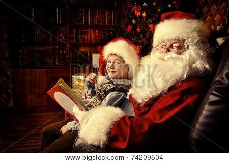 Santa Claus in his everyday clothes in Christmas home decoration. Happy little boy helps Santa Claus get ready for Christmas.